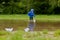 Portrait of cute kid boy playing with handmade ship. kindergarten boy sailing a toy boat by the waters` edge in the park