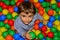 Portrait of a cute kid playing with colorful balls