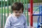 Portrait Cute litte boy playing  alone in playground, Candid Child pointing finger and looking down, Toddler boy playing in school
