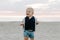 Portrait of Cute Little Baby Boy Child Playing and Exploring in the Sand at the Beach During Sunset Outside on Vacation in Hoodie