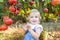 Portrait of cute little blondy baby girl looking at camera and picking ripe pomegrate fruits in the garden. Harvest and family tim