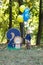 Portrait of a cute little boy on the background of nature. He`s holding balloons. Birthday of a two year old boy. Decor with the