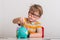 Portrait of cute little boy in glasses putting coin into a piggy bank on blurred background. Smart smart kid counting