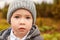 Portrait of a cute little boy in a gray hat and jacket with huge beautiful eyes