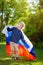 Portrait of cute little boy in public summer park with russian flag on background. Fans child supporting and cheering their