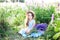 Portrait of a cute little brunette girl with long hair having fun on a stunning blooming meadow of lupines on a golden sunset back