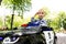 Portrait of cute little caucasain blond toddler boy enjoy having fun riding electric powered police toy car by asphalt