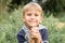 Portrait of a cute little four year old smiling happy candid european kid boy in nature in the garden in summer.