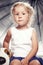 Portrait of a cute little girl in casual dress sitting with a plush toy in studio.