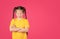 Portrait of cute little girl crying on pink background