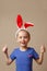 Portrait of a cute little girl dressed in Easter bunny ears shows gesture perfectly