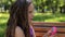 A portrait of a cute little girl of five years old on a bench in a summer park.