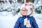 Portrait of a cute little girl in a hat and scarf in winter. preschool child with glasses in the forest. Happy child in