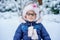 Portrait of a cute little girl in a hat and scarf in winter. preschool child with glasses in the forest. Happy child in