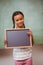 Portrait of cute little girl holding school slate