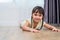 Portrait of cute little girl lying on floor with barefoot and looking at camera at home. People lifestyles concept