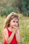 Portrait of cute little girl praying in the park, child keeping her hands together, closeup expression. Religion faith and believe