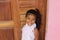 Portrait of cute little girl. She`s got your old wooden door. African-American mixed race child.