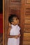 Portrait of cute little girl. She`s got your old wooden door. African-American mixed race child.