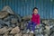 Portrait of cute little girl sitting on rocks at countryside