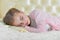 Portrait of cute little girl sleeping on beige pillow