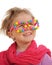 Portrait of cute little girl wearing funny glasses, decorated with colorful sweets, smarties