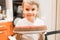 Portrait of a cute little happy candid caucasian five year old kid boy in white t-shirt holds a homemade baked cake or pie in his