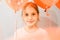 Portrait of a cute little happy candid smiling caucasian eight year old kid girl with red balloons against the background of a gra