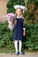 Portrait of a cute little seven year old first-grader girl with a bouquet of flowers ready to go to school. back to school concept