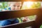 Portrait of cute mischievous caucasian blond baby boy holding wooden banister climbing staircase at outdoor backyard playground.