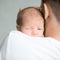 Portrait of a cute newborn hold at father shoulder