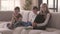 Portrait of cute older sister and two younger adorable brothers sitting on the couch looking at the camera smiling