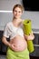 Portrait Of Cute Pregnant Female Stroking Touching Belly, Mom-to-be Expecting Baby, Stand With Fitness Mat After Yoga