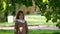 Portrait of cute redhead baby girl in spring park under the chestnut tree