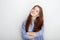 Portrait of cute redhead girl wearing blue striped shirt smiling with happiness and joy while posing against white studio