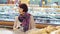 Portrait of a cute retired woman in a grocery store in the bread department.