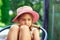 Portrait of cute sad little girl at big hat  looking sad at summer day