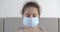 Portrait cute small child or little girl in a protective medical mask, with a sad disappointed face. Girl in a medical