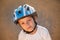 Portrait or cute small child in sport helmet standing on abandoned road in warm summer sunset