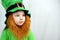 Portrait of cute small girl with decorative red beard in green dress and leprechaun\\\'s hat. Saint Patricks Day
