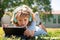 Portrait of cute smart clever school boy nerd doing homework outside. Kid distance learning concept. Distance education