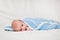 Portrait of a cute smiling infant baby crawling in a diaper, two-month baby child holds head