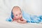 Portrait of a cute smiling infant baby crawling in a diaper, two-month baby child holds head