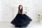 Portrait of cute smiling little girl in black princess fluffy dress