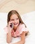 Portrait of cute smiling  little girl child calling by cell phone smartphone lying on the bed