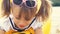 Portrait of a cute smling girl wearing sunglasses on the forehead,, sitting on summer beach.