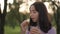 Portrait of cute teenage girl eating sandwich drinking juice in slow motion outdoors. Pretty relaxed Caucasian