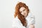 Portrait of cute tender ginger girl with curly hair looking at camera over white background.