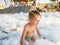 Portrait of cute toddler boy playing and having fun with lots of soap foam the beach disco party