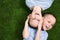 Portrait of cute twin brothers on green grass, top view